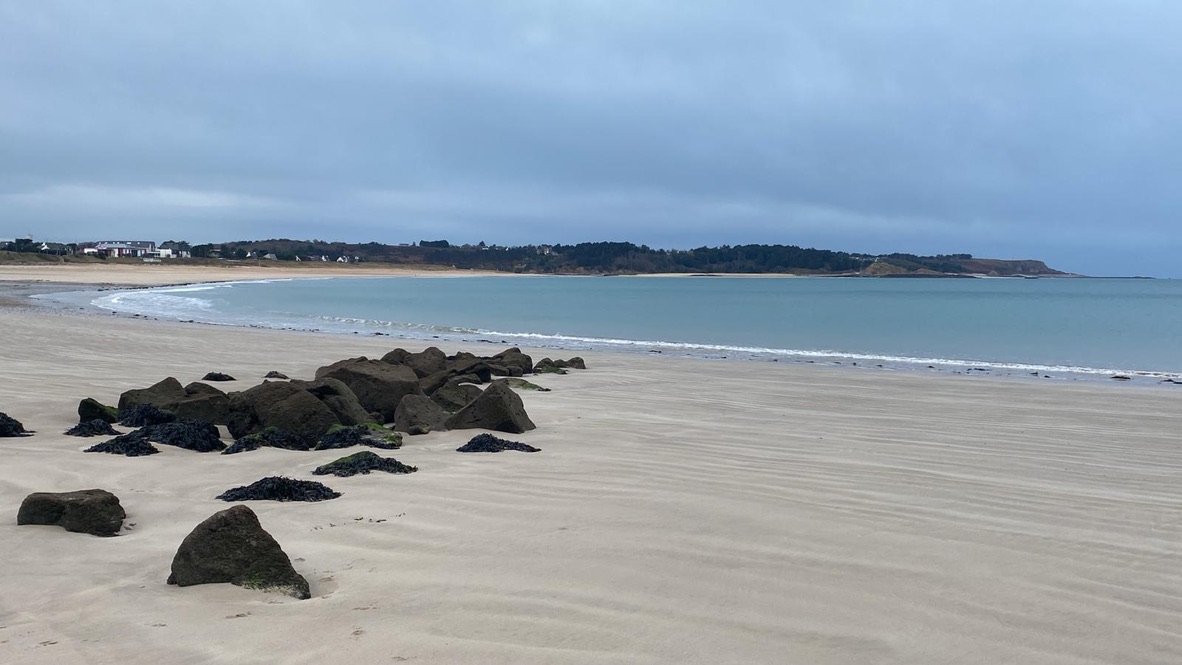Grande plage de sable avec des rochers à marée basse